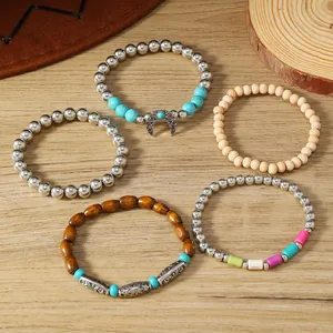 Detalle de pulseras bohemias con cuentas turquesas y colgante de media luna en estilo retro