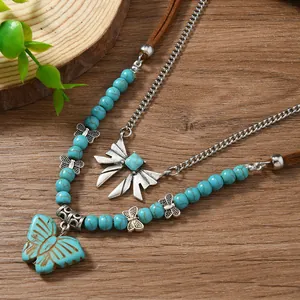 Détail macro du collier bohème multicouche avec perles turquoise et papillons