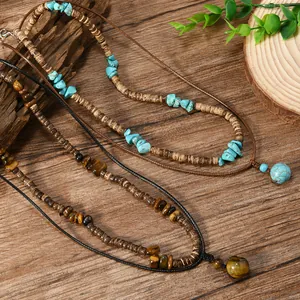 Boho-Halsketten mit Tigerauge, Türkis und Holzperlen auf rustikalem Holzhintergrund