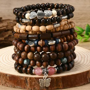 Macro shot of bohemian wood beads with heart charms and tree of life pendant on a wood base