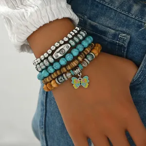Primer plano de un conjunto de pulseras bohemias con cuentas de turquesa y colgante de mariposa
