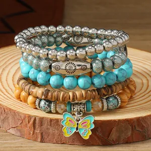 Detalle macro de pulsera multicapa con cuentas de turquesa y un colgante de mariposa