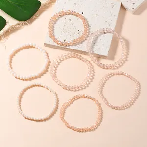 Detailed view of seven stacked faceted crystal stretch bracelets in warm neutral tones