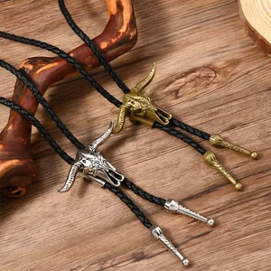 Detail von Vintage Bullenschädel-Bolo-Krawatten in Gold und Silber auf rustikalem Holz