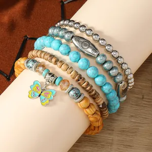 Detalle macro de pulseras bohemias de varias capas con cuentas turquesas y dije de mariposa