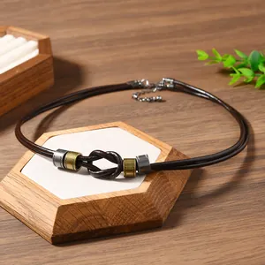 Detail of western style leather necklace featuring a hand-tied knot and antique metal beads