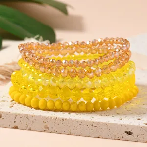 Close-up of five-layer yellow crystal beaded bracelets on a textured stone stand