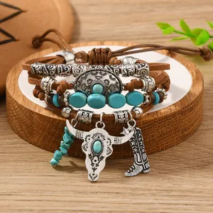 Detail of bohemian multilayer bracelet featuring turquoise beads and cow skull charm