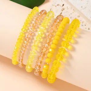 Set of six yellow beaded stretch bracelets with crystals and amber stones on display