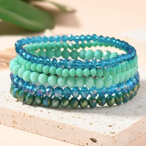Close-up of bohemian multilayer stretch bracelets with faceted green crystal beads