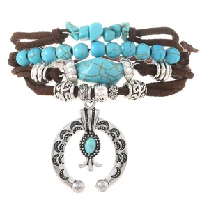 Detail of bohemian multilayer bracelet with turquoise beads and large horseshoe pendant