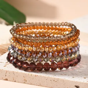 Detailed close-up of earth-toned multi-layer crystal bead elastic bracelets on stone
