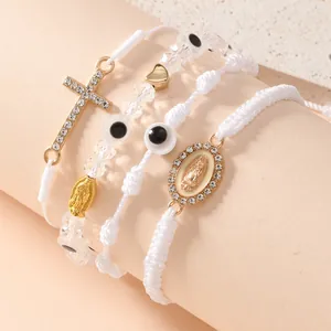 Dettaglio del set di quattro bracciali religiosi intrecciati con croce e malocchio