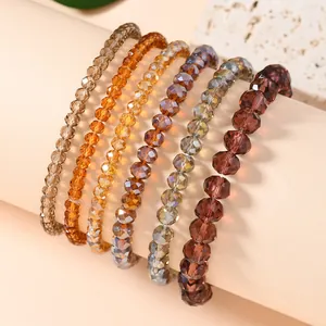 Close-up of six faceted crystal beads stretch bracelets in amber and champagne tones
