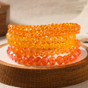 Close-up of stacked faceted crystal beaded bracelets in vibrant gradient orange tones