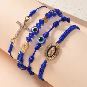 Dettaglio del set da 4 braccialetti blu intrecciati con croce e ciondolo malocchio