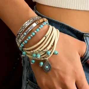 Detailed close-up of Bohemian layered bracelet set with turquoise beads and sun charm