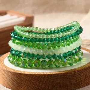 Macro view of multi-layer green crystal beaded stretch bracelets on a wooden stand