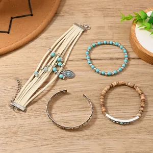 Close-up of bohemian stackable bracelets set with turquoise beads and tassel charms