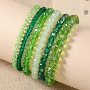 Macro detail of six-piece green crystal beaded elastic bracelets set for women