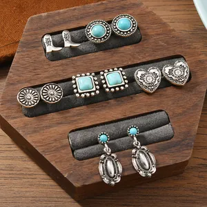 Set di orecchini bohémien con turchese e ciondoli vintage su espositore in legno