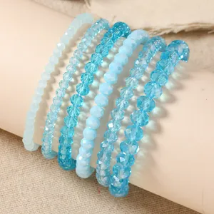 Detailed view of 6-piece blue crystal beaded stretch bracelets on a display stand