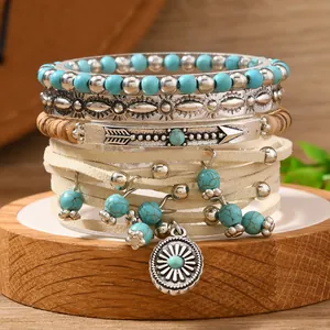 4-piece Bohemian stackable bracelet set with turquoise beads and sun charm on wood