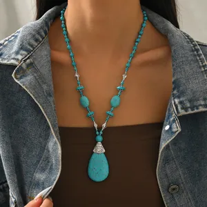 Boho Türkis Perlenkette mit großem Tropfenanhänger auf einer Jeansjacke getragen