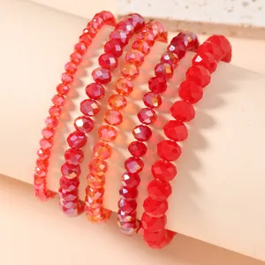 Close-up of red faceted crystal bead stretch bracelets set with glossy metallic finish