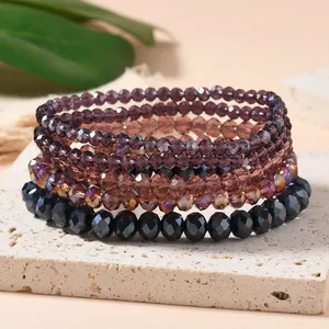 Macro detail of multi-layered faceted crystal beaded elastic bracelets on stone pedestal