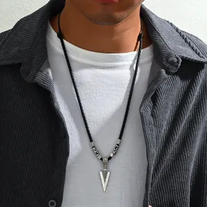 Détail du pendentif flèche en argent pour homme sur un collier en cuir tressé noir