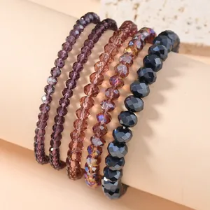 Detail view of 5-piece faceted crystal stretch bracelets in navy and purple tones