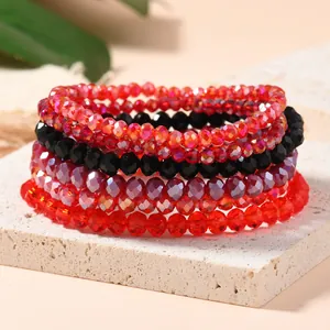 Detail of stacked multilayer elastic bracelets with red, black and purple crystal beads