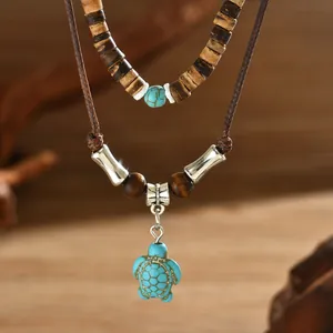Détail d'un collier bohème double épaisseur avec perles en bois et pendentif tortue