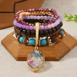 Detail of bohemian layered beaded bracelet featuring turquoise, crystal, and teardrop pendant