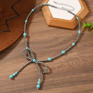 Λεπτομέρεια boho κολιέ με τυρκουάζ χάντρες και σχέδιο φιόγκου σε ξύλινο φόντο