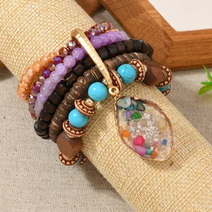 Detail of bohemian multilayer beaded bracelet with faux turquoise and teardrop stone pendant