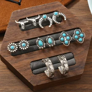 Dettaglio di set orecchini vintage bohémien con turchese su espositore in legno