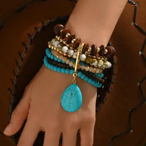 Bohemian multi-layer stackable beaded bracelet with turquoise pendant on suede background