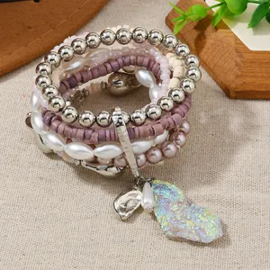 Close-up of Bohemian layered beaded bracelets with iridescent crystal cluster charm