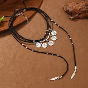 Detail of bohemian black suede wrap necklace with silver coins and feather pendants