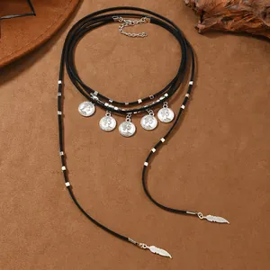 Detailed view of bohemian layered necklace with vintage coins and silver feather charms