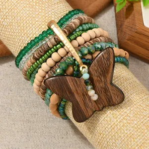 Detalle de la pulsera bohemia con cuentas de madera y un gran colgante de mariposa