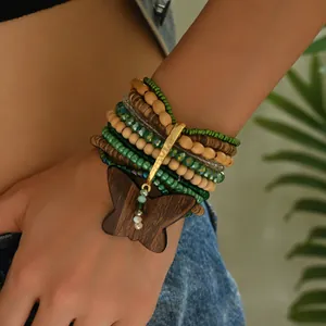 Detalle de una pulsera bohemia de capas con cuentas de madera y colgante de mariposa