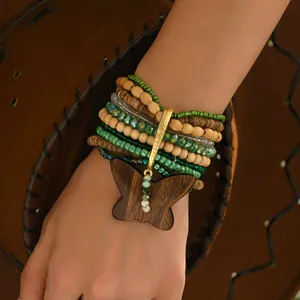 Primer plano detallado de una pulsera multicapa con cuentas y dije de mariposa de madera