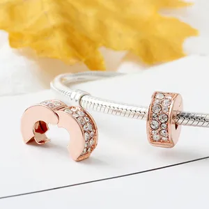 Detailed view of rose gold clip charm with pave-set crystals on a silver snake chain