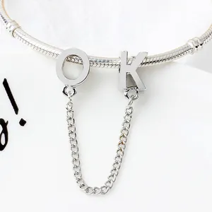 Vista macro del bracciale a catena serpente argento con ciondoli lettere OK e catena di sicurezza