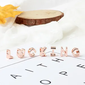Primer plano de cuentas de letras LUCKING en oro rosa para creación de joyas DIY