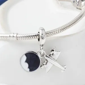 Silver airplane pendant bracelet with blue enamel charm and snake chain on a heart tray