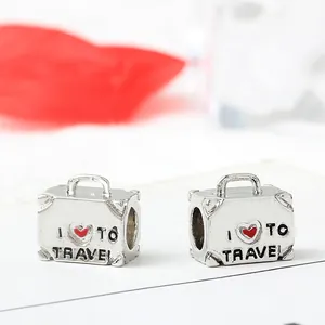 Silver suitcase bead charms featuring a red heart and I Love To Travel engraving
